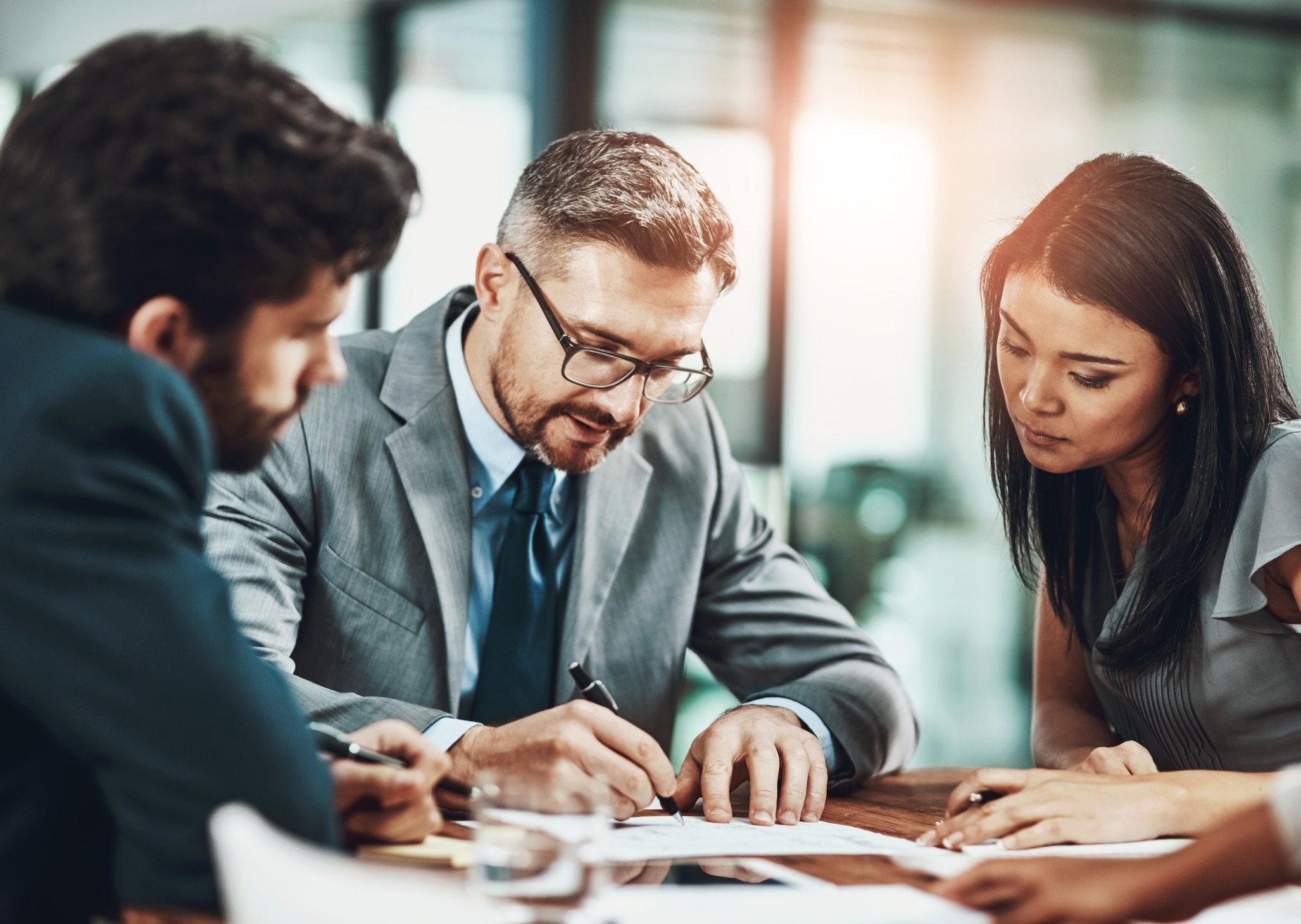 Business, people and writing of plan, report and paperwork for speech of politician and government. Documents, reading and ceo with employees, brainstorming and publicist in boardroom for ideas Putting productivity in focus